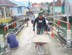 Satgas TMMD dan Warga Gotong Royong Cat Dermaga Desa Umbele