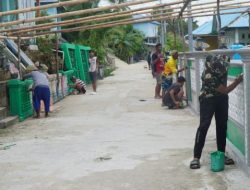 Satgas TMMD Bersama Warga Gotong Royong Cat Pagar di Desa Umbele